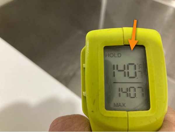 Thermometer showing excessively hot water from faucets, a surprisingly common problem found during a new construction inspection